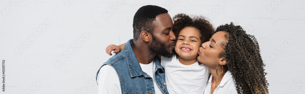 happy african american couple kissing daughter on grey, banner happy african american couple kissing daughter on grey, banner