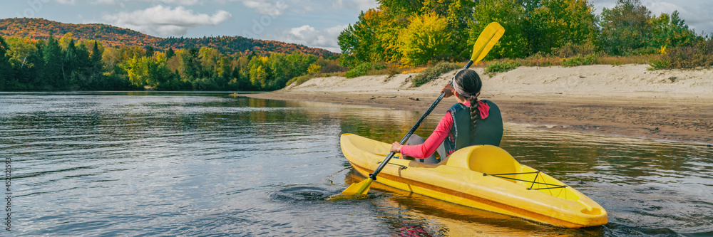 Obraz premium Kayak on river in Laurentians, Quebec .Canada travel destination banner. Woman kayaker kayaking down the river in Mont-Tremblant.