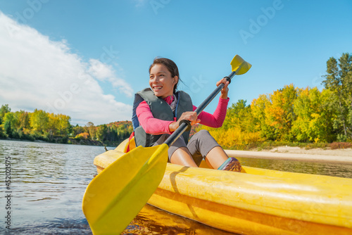 Kayak fun water sports on river in Laurentians, Quebec, Canada. Summer travel destination. Happy Asian woman kayaker kayaking in lake.