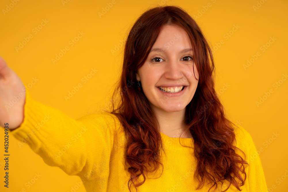 Young woman looking at camera and taking a selfie. Young woman looking at camera and taking a selfie.