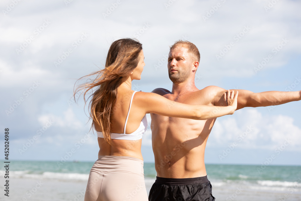 young man stretching and exercising outdoors from trainer suggesting on the beach young man stretching and exercising outdoors from trainer suggesting on the beach