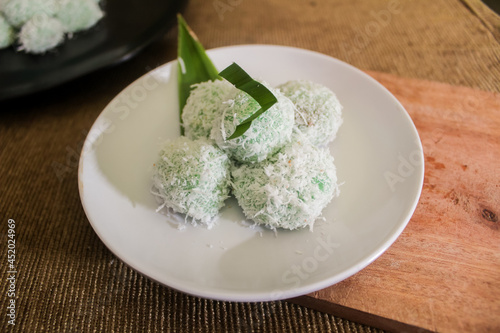 The traditional cake from Indonesia (Klepon) is green in color and topped with grated coconut.