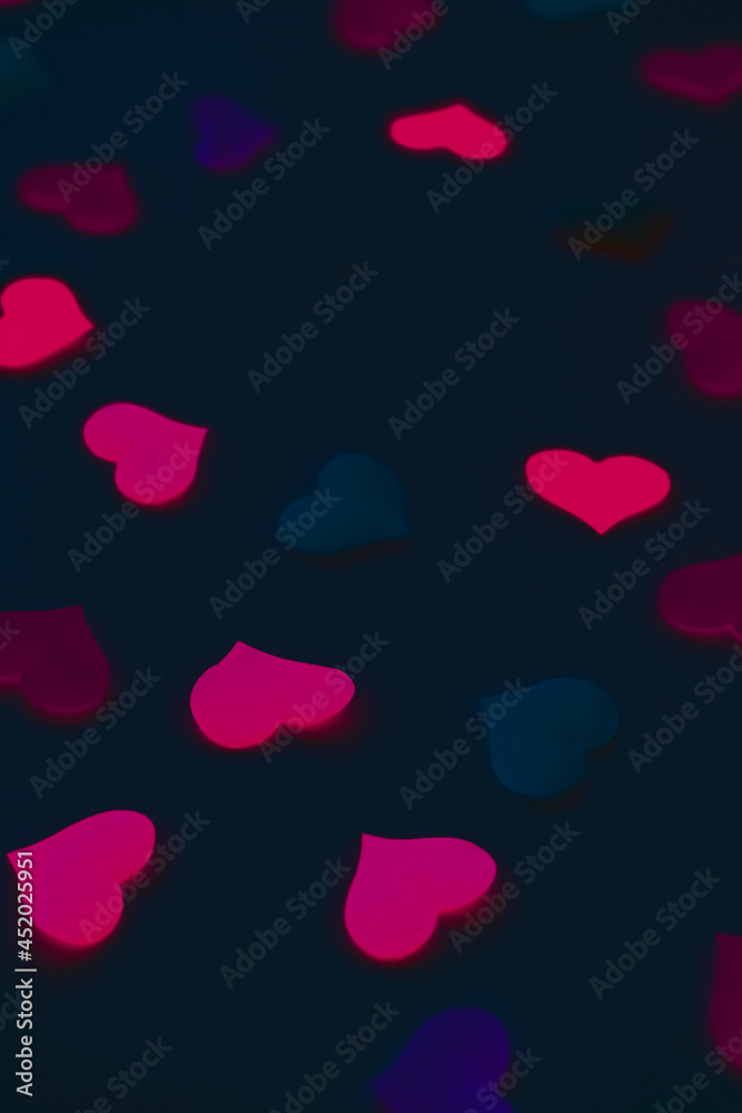 Romantic vertical background for the decoration of the holiday of all lovers. Minimalistic dark black background with hearts Romantic vertical background for the decoration of the holiday of all lovers. Minimalistic dark black background with hearts