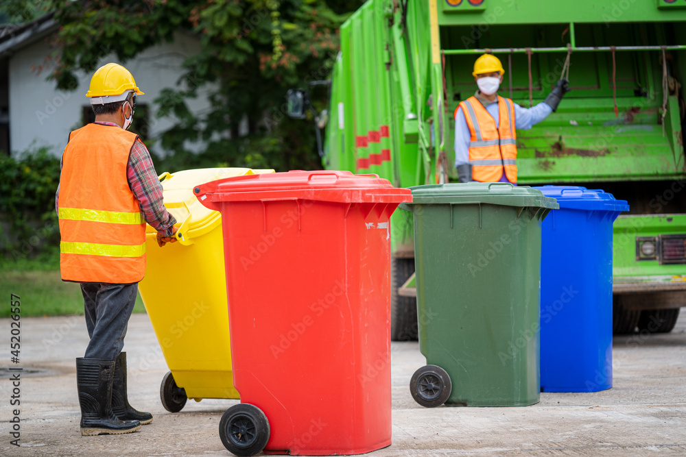 Garbage men working together on emptying dustbins for trash removal