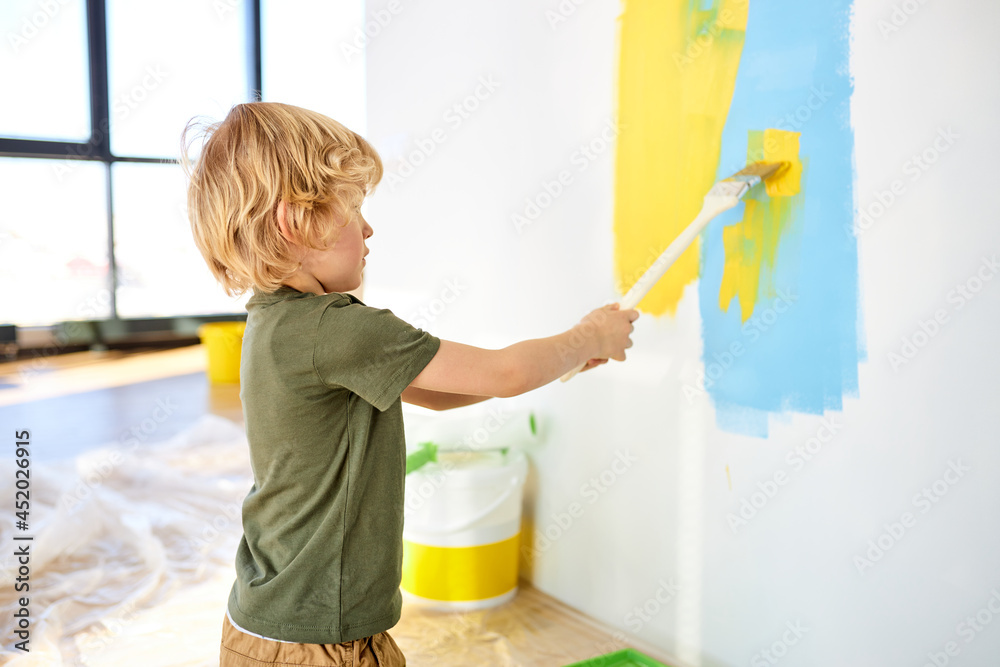 Funny little toddler boy painting the wall with color in new house. Family  repair apartment home. Happy child paints the wall, applying with  paintbrush, having fun with brush, indoors. Stock Photo |