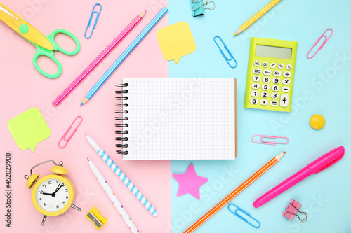 School supplies with blank notepad for text on colorful background