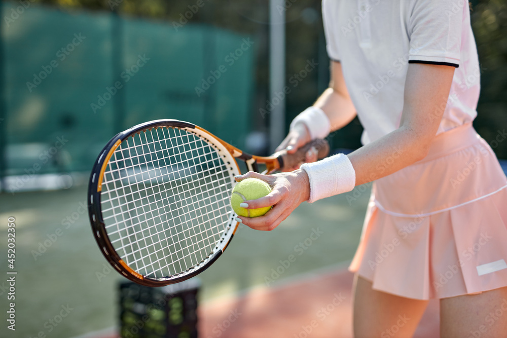 cropped woman playing tennis hitting ball, caucasian athlete female throwing racket wearing skirt and t-shirt. slim sportive lady enjoy playing tennis, exercising and training in sports ground