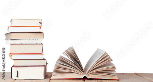 isolated opened book with stack of books on the wood table in the white background with copy space