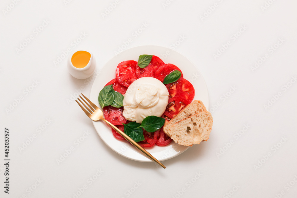 Delicious fresh cheese made from cream and milk - burrata. Italian tender cheese with tomato and greens salad, bread and olive oil. Delicious fresh cheese made from cream and milk - burrata. Italian tender cheese with tomato and greens salad, bread and olive oil.