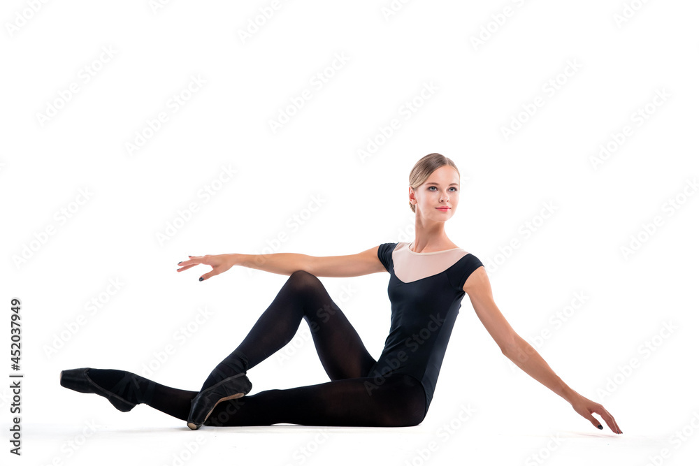 young ballerina in black pointe shoes and leotards posing sitting, isolated on white background young ballerina in black pointe shoes and leotards posing sitting, isolated on white background