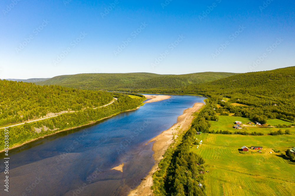 Aerial view of river Karasjohka, fields and forest at the border of Finland and Norway