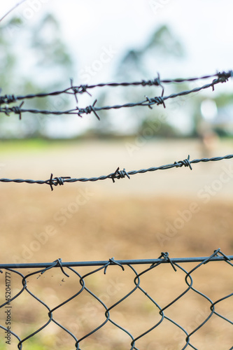 close up barbed wire fence with blurry background