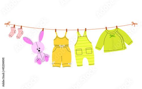 A flat vector cartoon illustration of kids things that are dried on a clothesline using clothespins. Isolated design on a white background.