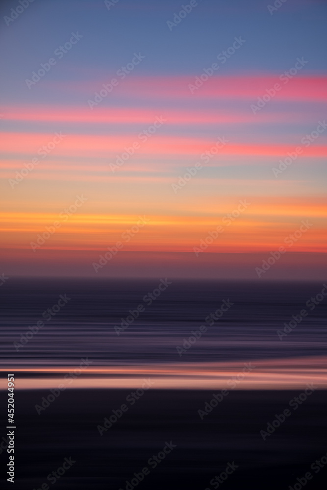 Haystack rocks silhouette against colorful sunset evenings on the beach