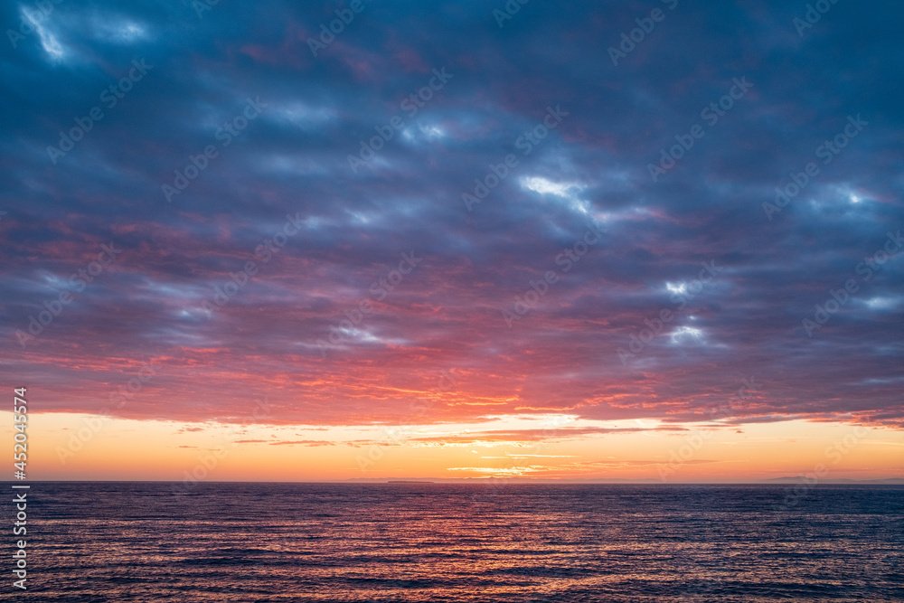 Obraz premium A color sunset colors the clouds above the ocean