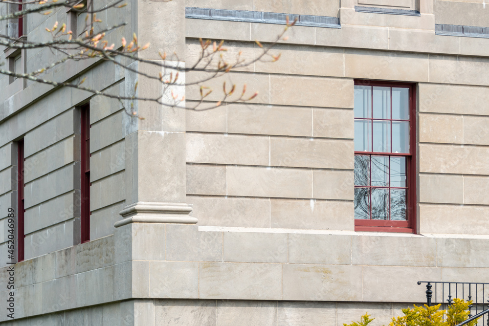 The exterior of a vintage limestone block wall with multiple windows