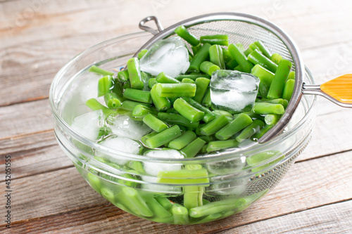 Green beans in a colander. Boiled or blanched vegetables on a table photo
