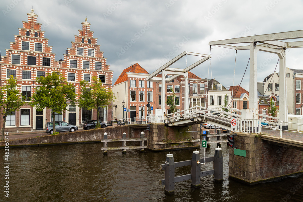Canal houses on the Spaarne in the center of the historic Dutch city of Haarlem, with the Gravesteen Bridge over the Spaarne in the foreground.