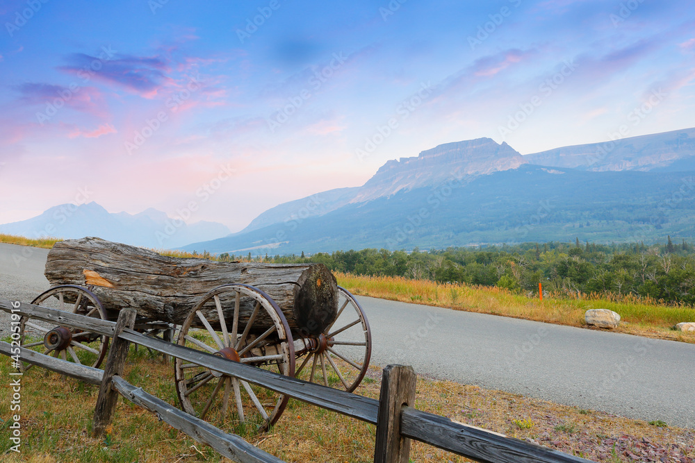 Montana Landscape with an old wagon and a wood log at sunrise in West Glacier, Montana USA