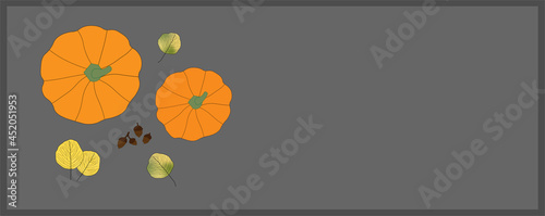 Bright colored autumn leaves and pumpkins on grey background with copy space on right hand side. Top view. Fall, seasonal, Thanksgiving.