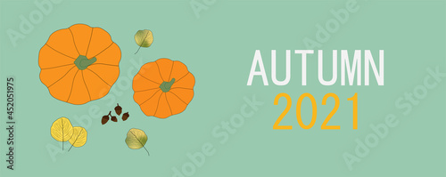Bright colored autumn leaves and pumpkins on blue background with Autumn 2021 message. Top view. Fall, seasonal.