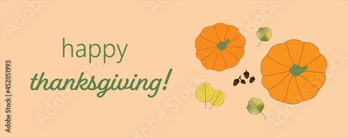 Bright colored autumn leaves and pumpkins on pale orange background with Happy Thanksgiving message. Top view. Fall, seasonal.