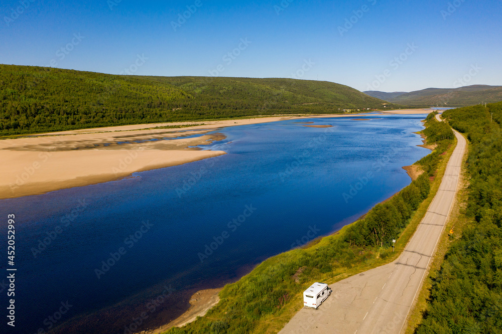 Aerial view of river Karasjohka, sandy beach and a camper at the border of Finland and Norway