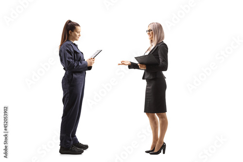 Full length profile shot of a businesswoman talking to a female auto mechanic