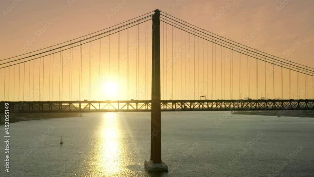 Ponte 25 de Abril, Lisbon, Portugal, Europe. An icon of Lisbon with cityscape behind as seen from top. Aerial view of picturesque sunset in the background of suspension bridge. High quality 4k footage Ponte 25 de Abril, Lisbon, Portugal, Europe. An icon of Lisbon with cityscape behind as seen from top. Aerial view of picturesque sunset in the background of suspension bridge. High quality 4k footage