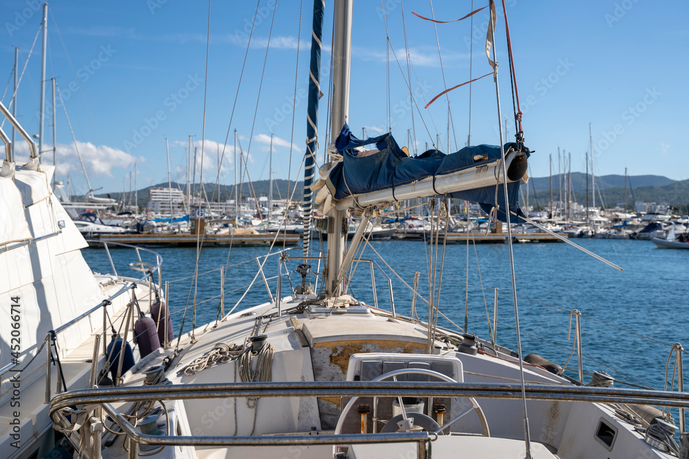 Obraz premium Moored nautical vessels at sea port San Antonio de Portmany, Balearic Islands, Ibiza, Spain. Sunny spring day.