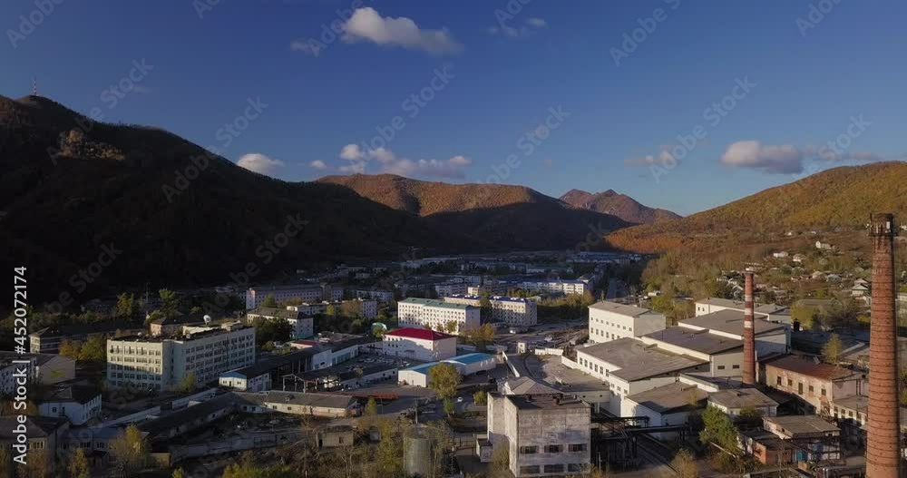 Ascending aerial view of small white town situated in a valley between green mountains. Nice sunny day. Autumn Ascending aerial view of small white town situated in a valley between green mountains. Nice sunny day. Autumn