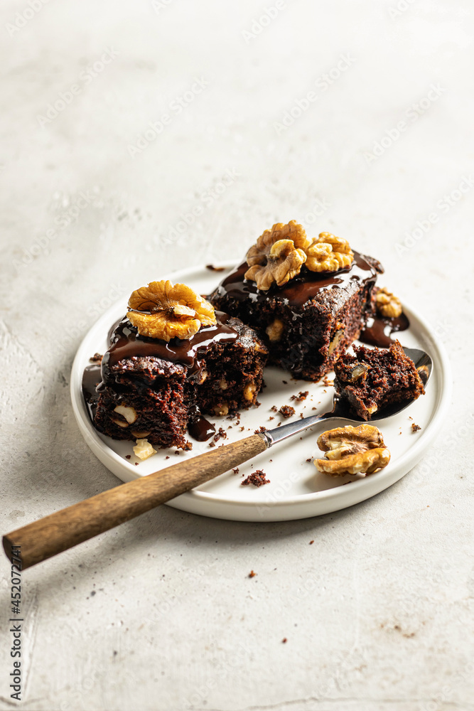 Chocolate Zucchini brownie on a white plate on light gray