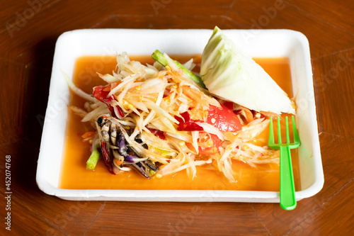 Papaya salad, Thai food name Som Tum, on white foam plate background