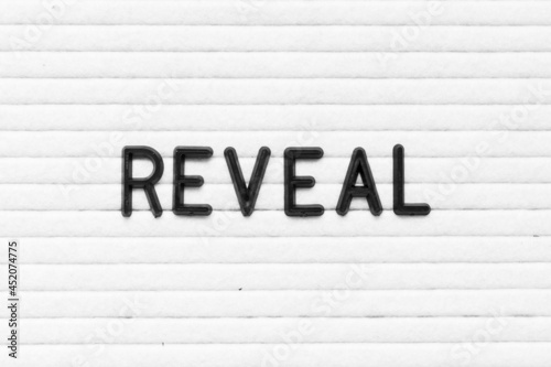 Black color letter in word reveal on white felt board background photo