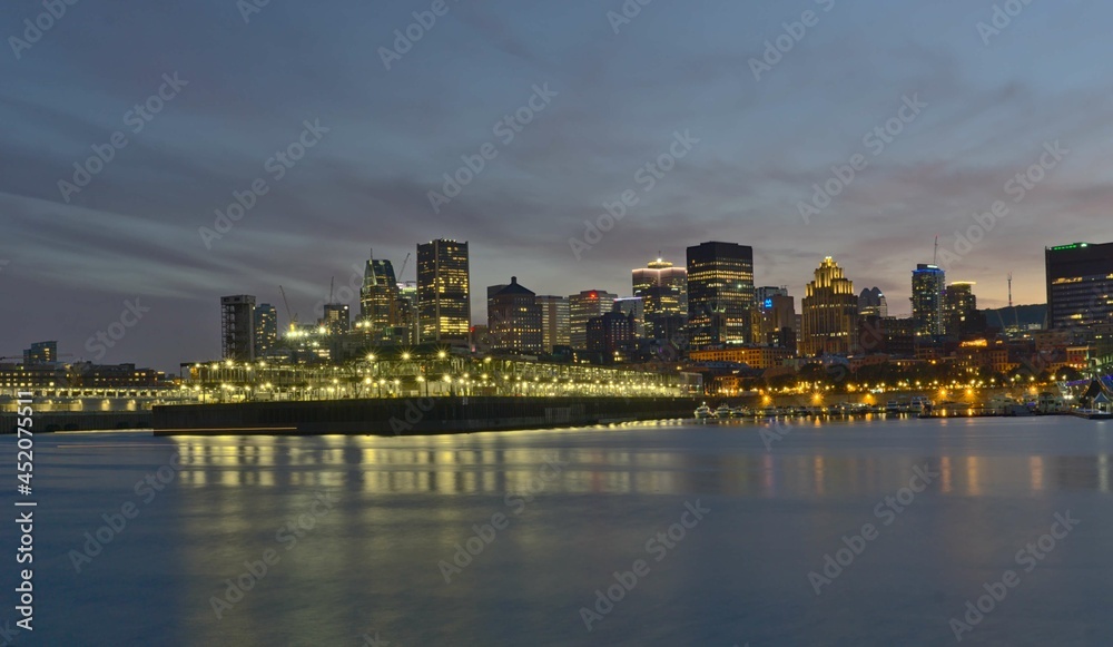 Montreal Downtown skyline during the twilight blue hour. Foreground is Saint Lawrence (Laurent) river.