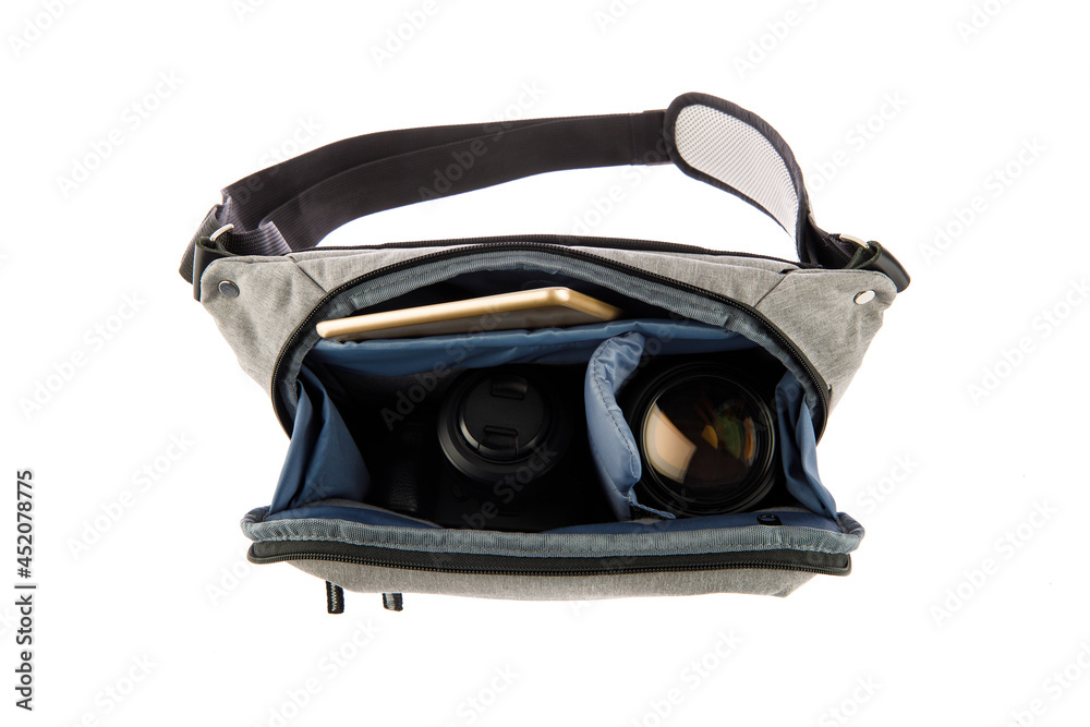 Isolated close up studio shot of small photographer modern fashionable gray shockproof waist bag soft compartment fanny pack carry digital dslr camera len and smartphone inside on white background Isolated close up studio shot of small photographer modern fashionable gray shockproof waist bag soft compartment fanny pack carry digital dslr camera len and smartphone inside on white background