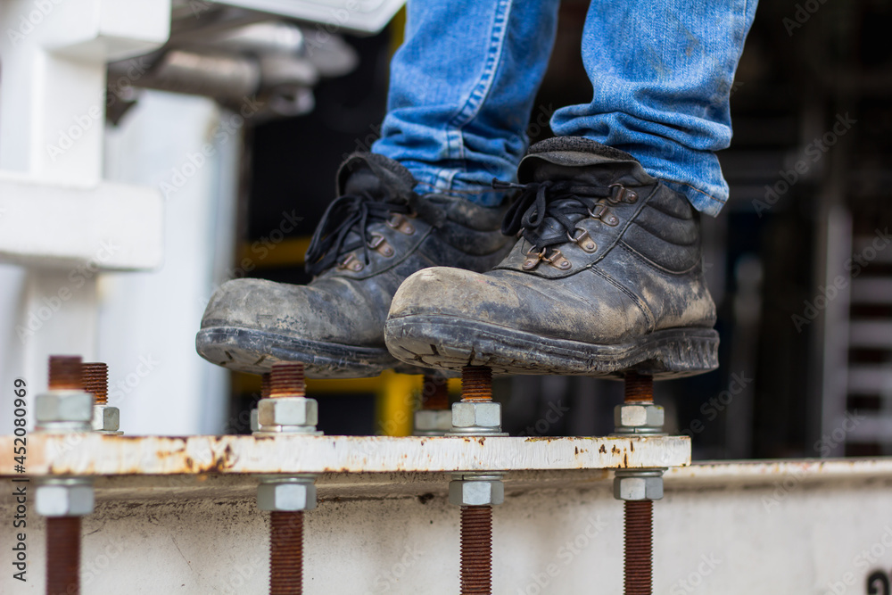 Wear safety shoes to ensure safety at work. construction workers wear