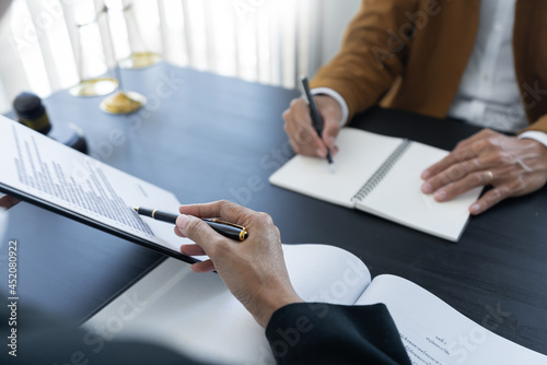 law,libra scale and hammer on the table, 2 lawyers are discussing about contract paper, law matters determination, showing paper and notes