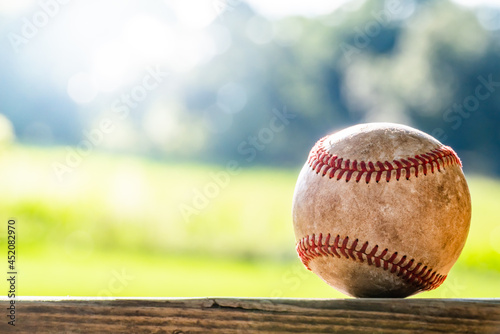 Baseball backlit by evening sunlight in isolated focus