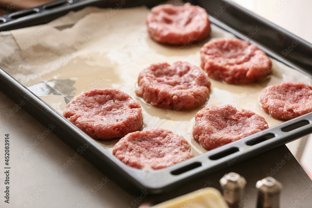 Baking tray with minced meat boats on table
