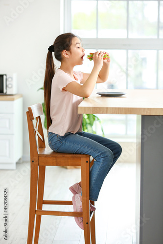 Little girl eating tasty sa...