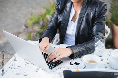 Latin businesswoman drinking coffee. Smiling businesswoman networking wiht tablet and cellphone