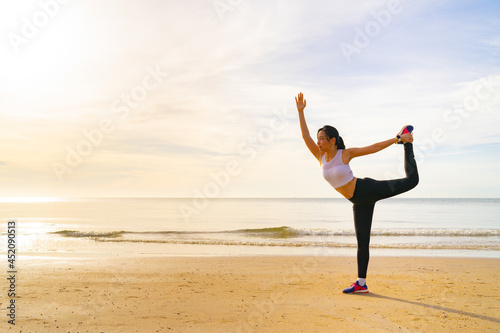 Women yoga on the beach at morning with beautiful sunrise