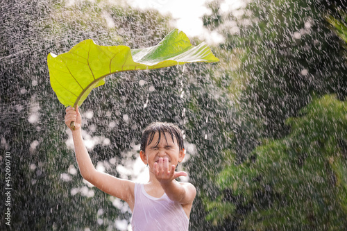 Photography Boy smiling, having fun, stands with leaf on her head standing in the rain
