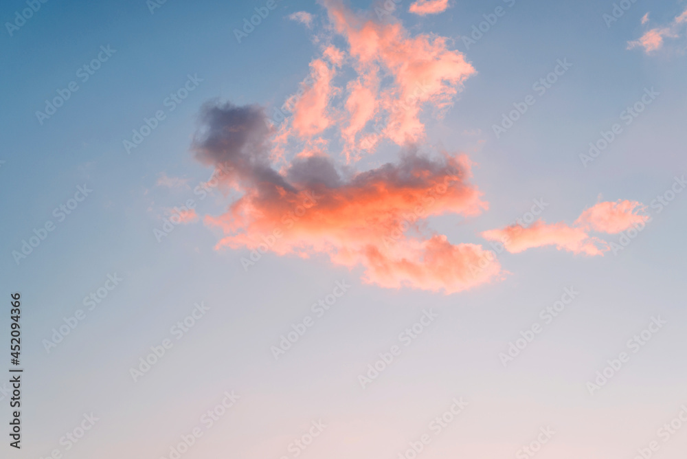 Heavenly sunset landscape. Fiery cloud against the background of the evening blue sky. Minimalistic natural backdrop, high.