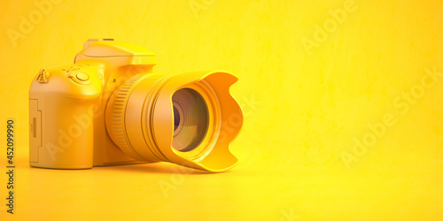 Yellow DSLR photo camera on yellow background.