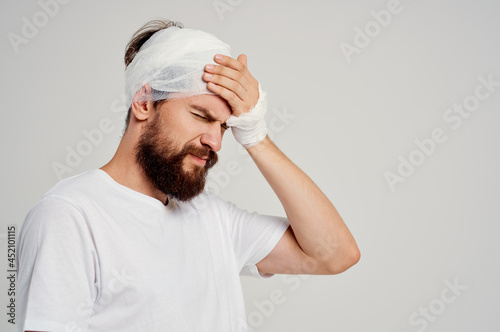 bearded man head and arm injuries health problems light background