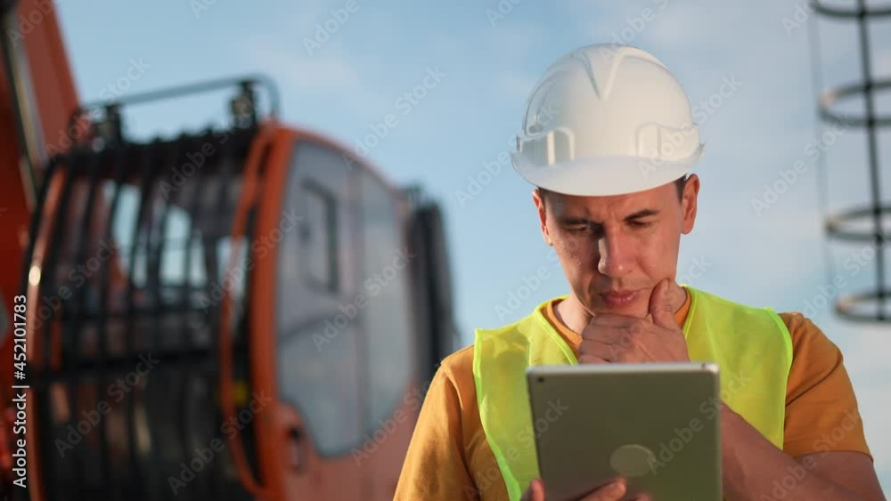 worker in hard a hat with digital tablet near excavator. construction site driver with digital tablet. industry construction concept. worker in hard hat near business excavator truck in uniform. worker in hard a hat with digital tablet near excavator. construction site driver with digital tablet. industry construction concept. worker in hard hat near business excavator truck in uniform.