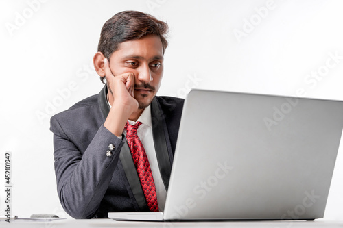 Young indian man in suit and working on laptop at office