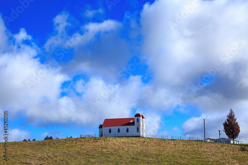 The old Ratana Church at Raetihi, New Zealand, standing on a hillside against a beautiful blue sky  photo
